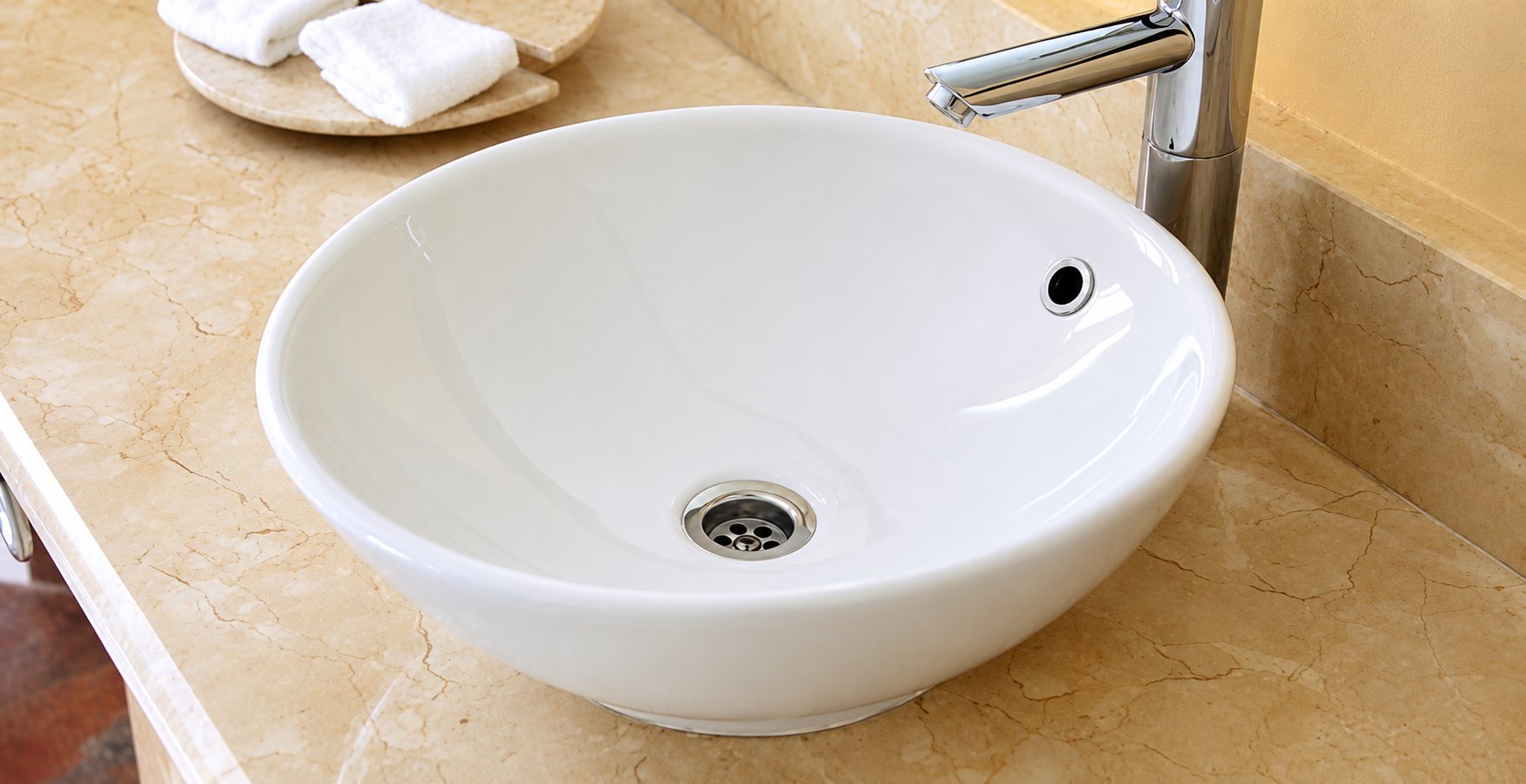 Vasque ronde blanche posée sur un plan en marbre beige